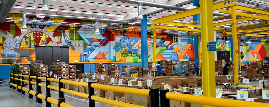 Total view of a factory warehouse interior from the left angle side with a big wall painting. Wall painting by Dado.