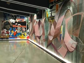 Right total view of a decorated garage wall recreating a street underground atmosphere with spray can lettering artworks and torn paper posters. Artwork by Dado.