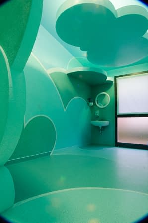 Partial portrait view of a relaxing room inside a s SPA decorated and painted all over with cloud-like bas relief in the tones of sky-blue and water green. Decoration by Dado.