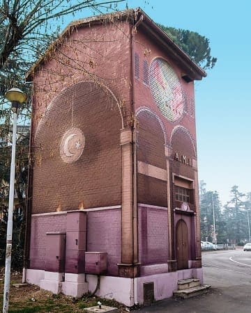 A Church interiors detailed mural graffiti, painted on all four sides of an electric cabin small building, gives the illusion of a realistic interiors accessible space, back view. Artwork by Dado