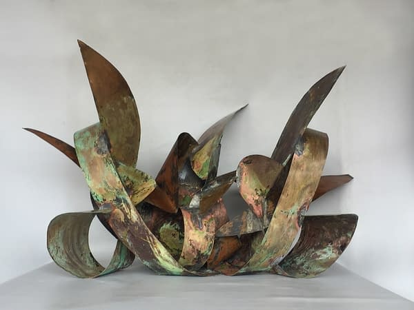 Front view of a copper sculpture made of sinous intricated ribbons forming the simbol of the infinite in mixed with natural elements. Artwork by Dado