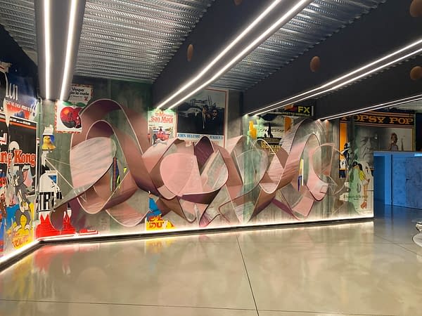 Total view of a decorated garage wall recreating a street underground atmospherewith spray can lettering artworks and torn paper posters. Artwork by Dado.