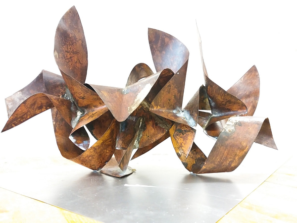 Bent and torched copper ribbons in original copper color with some oxidation stains and welding marks. Artwork by Dado
