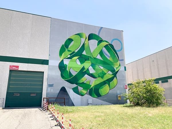 Wide location view of a mural painting depicting a spherical wildstyle graffiti forming the tag Dado in green tones.