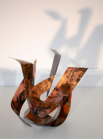 Front view of a sculpture made of copper ribbons forming M and G letters. Artwork by Dado