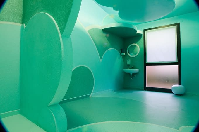 Total view of a relaxing room inside a s SPA decorated and painted all over with cloud-like bas relief in the tones of sky-blue and water green. Decoration by Dado.
