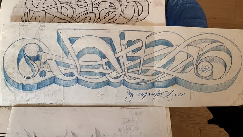Blue crayon graffiti sketch on white paper depicting the tag Dado in a simple 3D lettering style