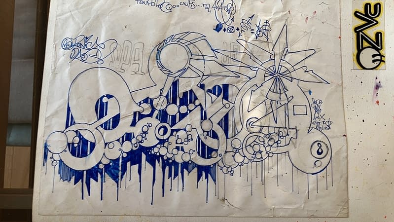Blue marker graffiti sketch on white paper depicting the tag Dado in a flat geometrical style decorated with bubbles lettering style
