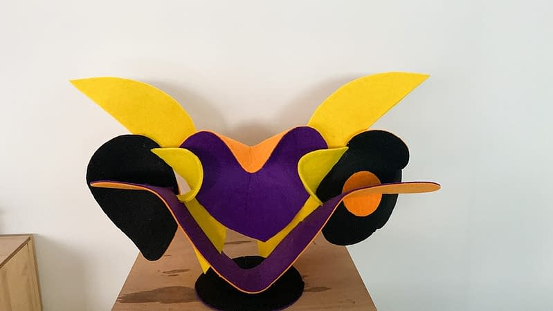 Front view of a sculpture made of thin bent layers with a soft felt finish in a mix of high saturated yellow, orange, purple and black colors. Artwork by Dado