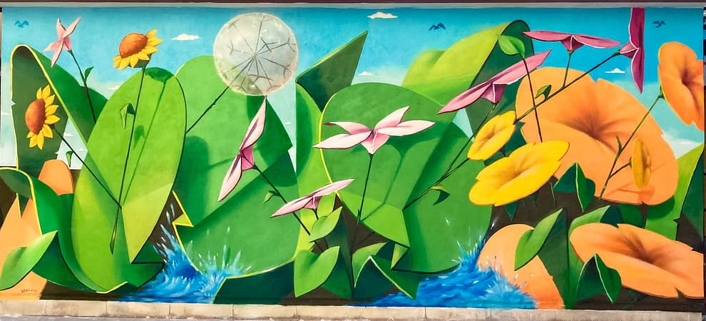 Total view of a large mural painting depicting big green leaves with geometric rounded shapes, composing the tag Dado, and big yellow-orange flowers along with smaller pink and light yellow flowers floating on deep blue water. Artwork by Dado